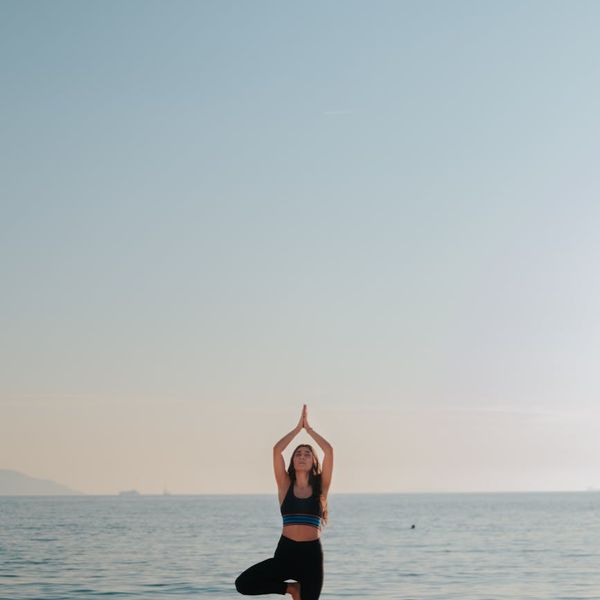 A woman meditating outdoors at sunrise, feeling the morning energy.
